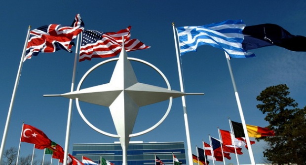 L&aacute; cờ của NATO được tạo th&agrave;nh từ một biểu tượng hoa hồng la b&agrave;n m&agrave;u trắng&nbsp;đặt tr&ecirc;n một c&aacute;nh đồng m&agrave;u xanh đậm.