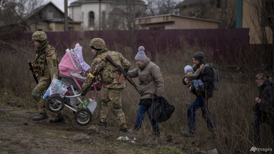 Một gia đình được giúp đỡ băng qua sông Irpin ở ngoại ô Kiev, Ukraine, để đi lánh nạn, hôm 5-3. Ảnh AP