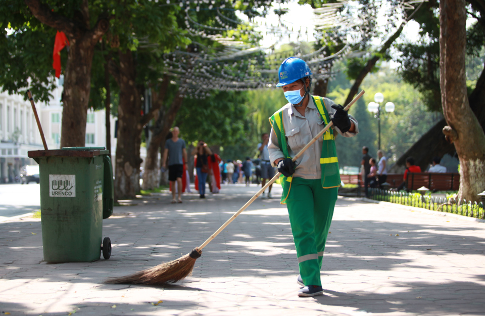 Nhân viên môi trường thu gom rác trên phố Đinh Tiên Hoàng, quận Hoàn Kiếm. Ảnh Công Hùng
