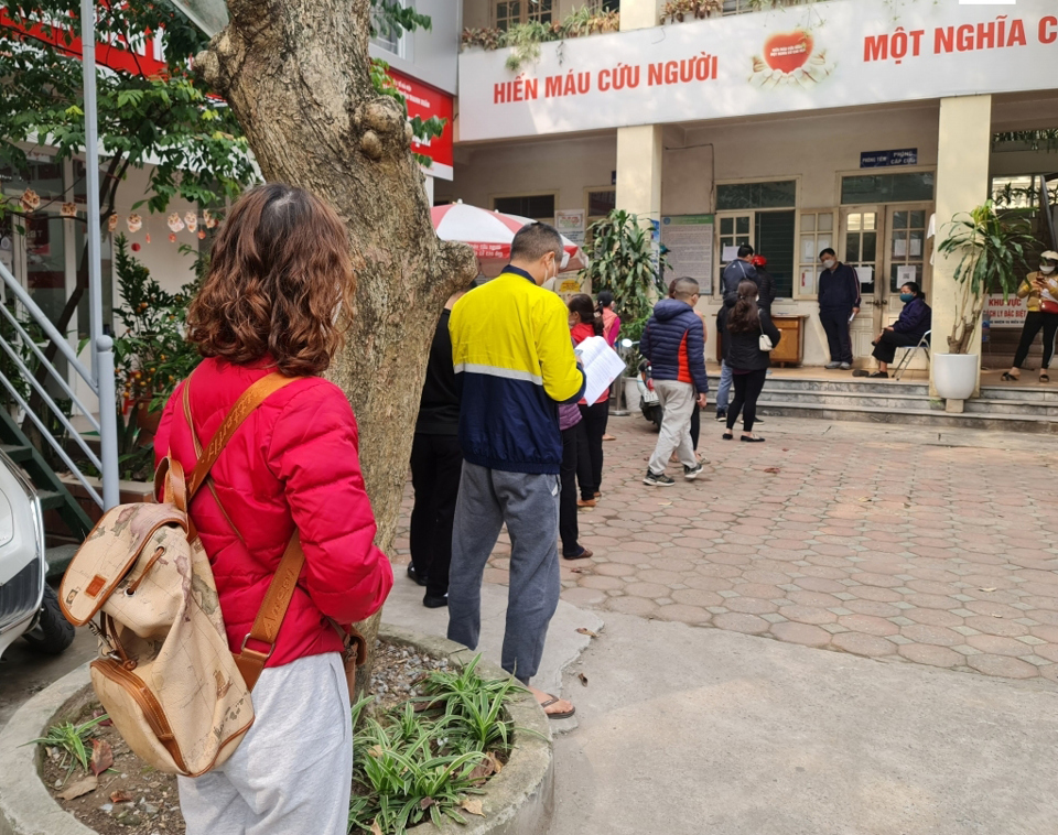 Người dân phường Nhân Chính, quận Thanh Xuân xếp hàng ở trạm y tế để chờ làm thủ tục xin giấy xác nhận F0 và khỏi bệnh​​​​​​. Ảnh Mai Hương