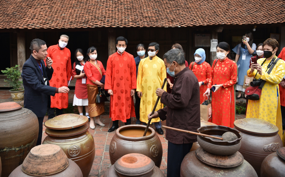 Khách du lịch quốc tế  tìm hiểu nghề làm tương tại Đường Lâm, Sơn Tây, Hà Nội. Ảnh Hải Nam