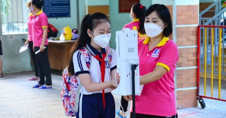 Học sinh ở TP Hồ Ch&iacute; Minh s&aacute;t khuẩn tay trước khi v&agrave;o lớp học. (Ảnh minh hoạ)