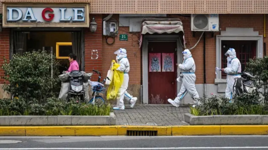 Nh&acirc;n vi&ecirc;n y tế mặc đồ bảo hộ đi tr&ecirc;n đường phố Thượng Hải, Trung Quốc ng&agrave;y 26/3. Ảnh: AFP