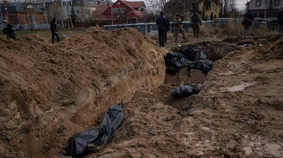 ジャーナリストは、2022年4月4日にウクライナの首都キーウの外にあるブチャの町の集団墓地を調べます。写真のホットスポット