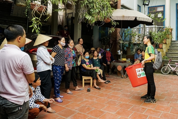 Cán bộ Trung tâm nông nghiệp hữu cơ - Học viện nông nghiệp Việt Nam hướng dẫn người dân cách xử lý rác tại nhà. Ảnh Live&Learn Việt Nam