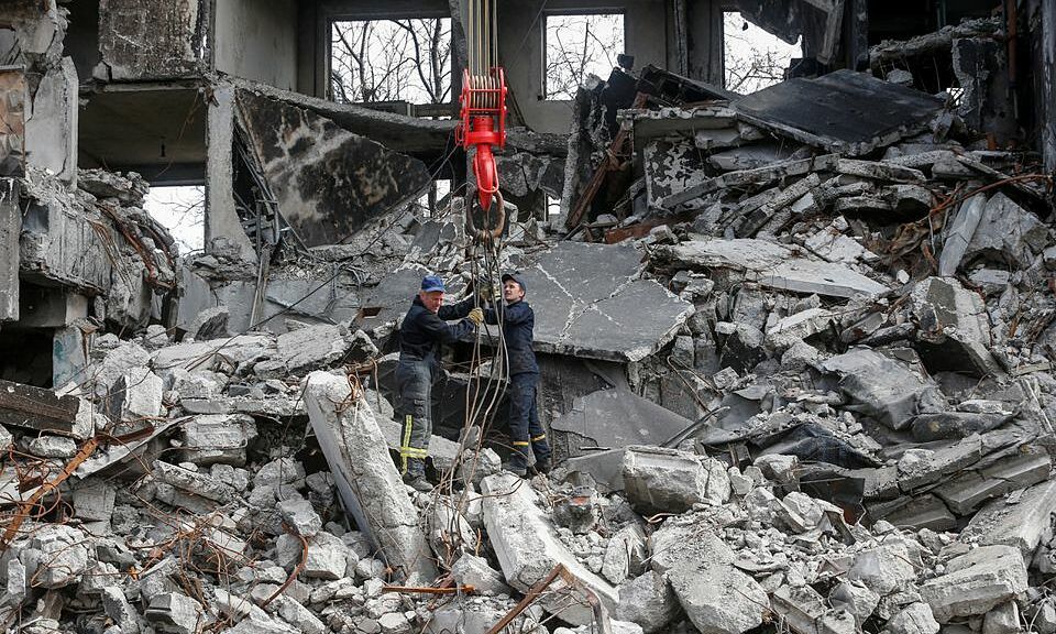 Nh&acirc;n vi&ecirc;n cứu hộ dọn dẹp một t&ograve;a nh&agrave; bị ph&aacute; hủy sau giao tranh ở Mariupol, Ukraine h&ocirc;m 10/4. Ảnh: Reuters.