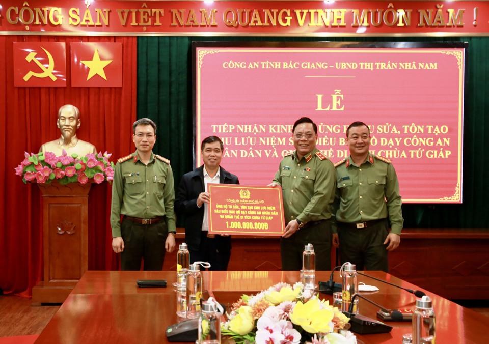 Trung tướng Nguyễn Hải Trung, Gi&aacute;m đốc C&ocirc;ng an TP H&agrave; Nội trao kinh ph&iacute; ủng hộ cho đại diện UBND thị trấn Nh&atilde; Nam.