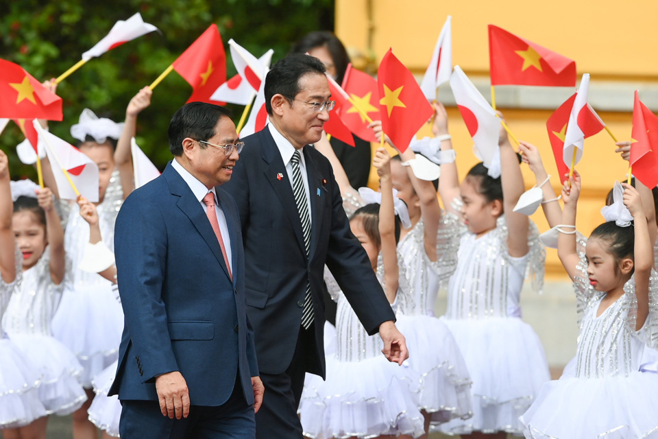 Thủ tướng Phạm Minh Ch&iacute;nh mời Thủ tướng Kishida Fumio bước tr&ecirc;n thảm đỏ trong tiếng vẫy ch&agrave;o của c&aacute;c em học sinh
