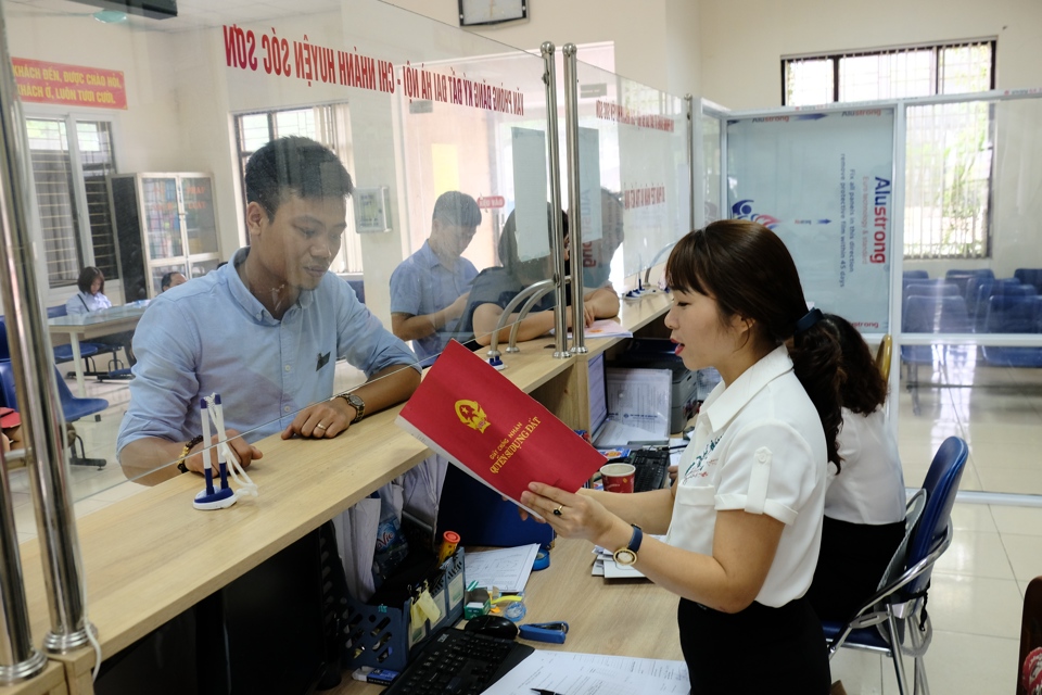 Hướng dẫn người dân làm thủ tục hành chính tại Bộ phận một cửa UBND huyện Sóc Sơn. Ảnh: Phạm Hùng