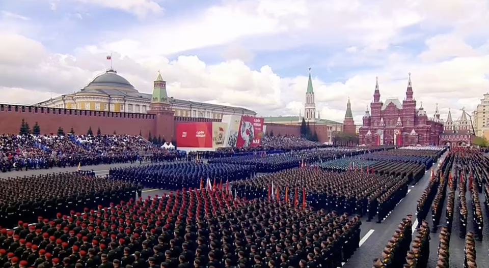Lễ duyệt binh bắt đầu với cuộc diễu h&agrave;nh của Đội cận vệ danh dự mang quốc kỳ Nga, c&ugrave;ng biểu ngữ Chiến tranh Vệ Quốc Vĩ đại phủ khắp Quảng trường Đỏ, thủ đ&ocirc; Moscow.