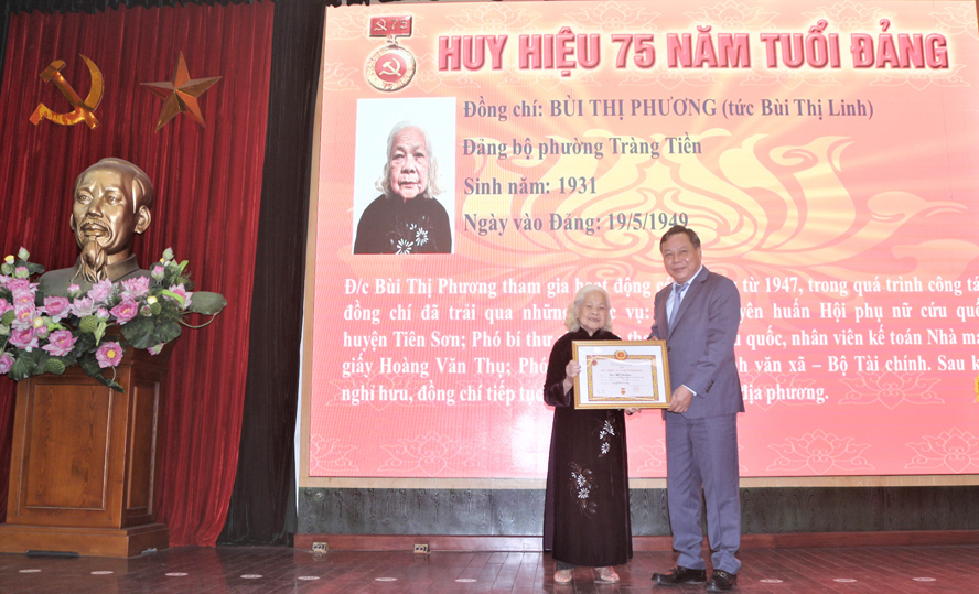 Ph&oacute; B&iacute; thư Th&agrave;nh ủy H&agrave; Nội Nguyễn Văn Phong trao Huy hiệu 75 năm tuổi Đảng cho đồng ch&iacute; B&ugrave;i Thị Phương, Đảng bộ phường Tr&agrave;ng Tiền.