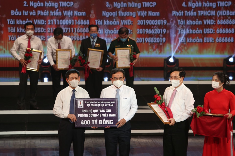 B&iacute; thư Đảng ủy, Chủ tịch HĐTV EVN (giữa) Dương Quang Th&agrave;nh&nbsp;trao biểu trưng 400 tỷ đồng ủng hộ Quỹ Vắc-xin ph&ograve;ng, chống Covid-19.