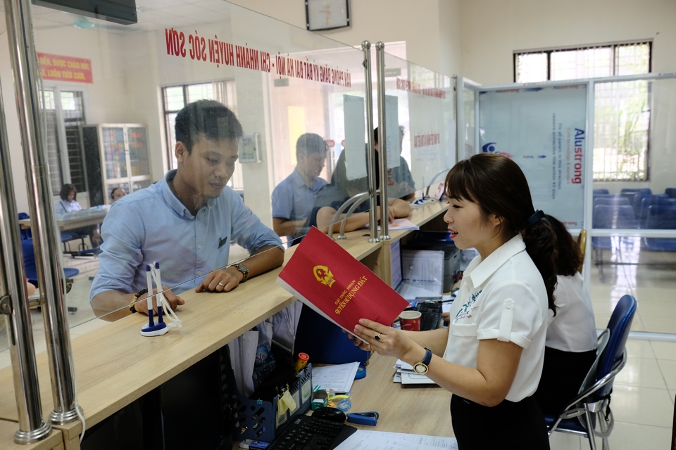 Cán bộ UBND huyện Sóc Sơn hướng dẫn người dân làm thủ tục hành chính. Ảnh: Công Hùng