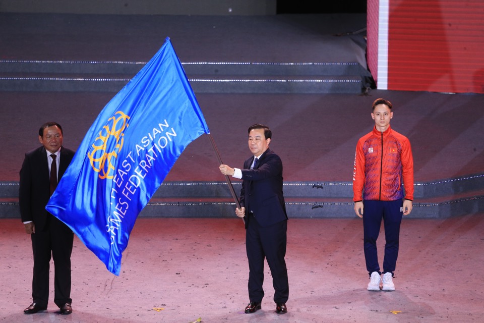 Trưởng Tiểu ban Khai mạc v&agrave; Bế mạc SEA Games 31, Ph&oacute; Chủ tịch UBND TP Chử Xu&acirc;n Dũng&nbsp;tiến h&agrave;nh nghi thức chuyển giao cờ&nbsp;Li&ecirc;n đo&agrave;n Thể thao Đ&ocirc;ng Nam &Aacute; cho đại diện của Campuchia.