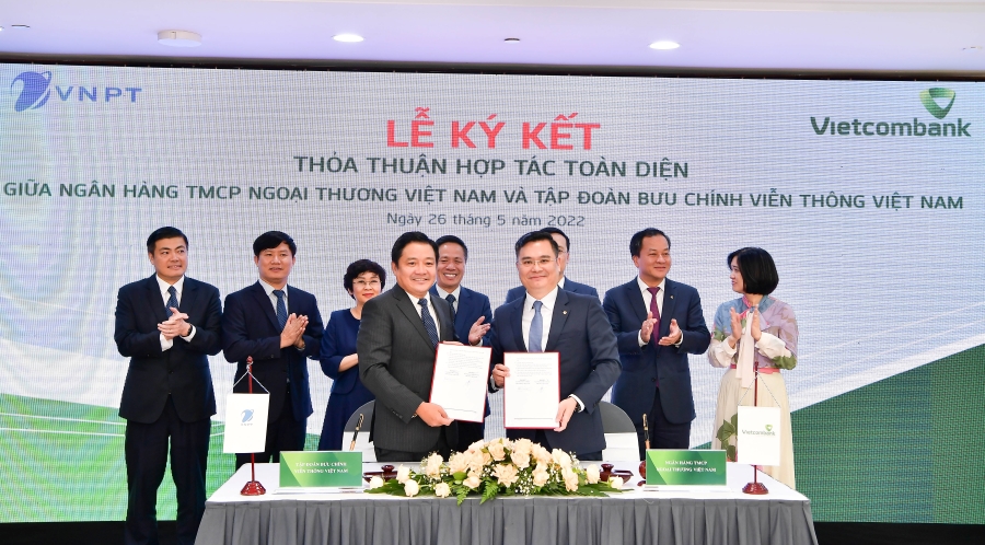 &Ocirc;ng Nguyễn Thanh T&ugrave;ng - Ph&oacute; Tổng Gi&aacute;m đốc Phụ tr&aacute;ch BĐH Vietcombank (b&ecirc;n phải) v&agrave; &ocirc;ng Huỳnh Quang Li&ecirc;m - Tổng Gi&aacute;m đốc VNPT thực hiện nghi thức k&yacute; Thỏa thuận hợp t&aacute;c to&agrave;n diện dưới sự chứng kiến của l&atilde;nh đạo 2 b&ecirc;n