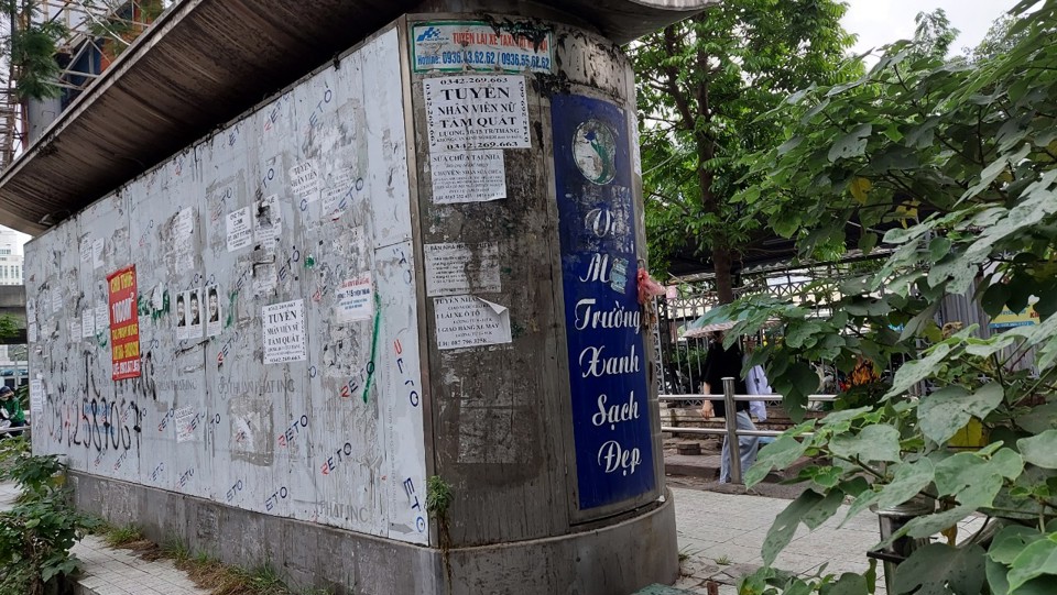 Nhà vệ sinh tại ngã tư đường Phạm Hùng - Nguyễn Hoàng rất nhếch nhác, tường nhà dán đầy quảng cáo.