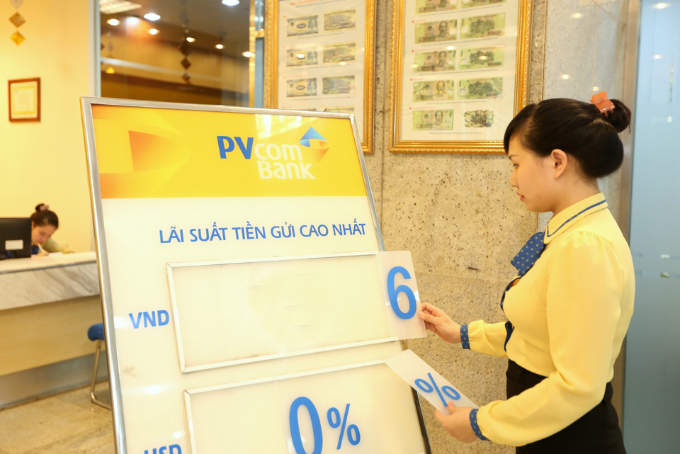 Nhân viên PVbank chi nhánh Hà Nội điểu chỉnh bảng thông báo lãi suất. Ảnh: Công Hùng