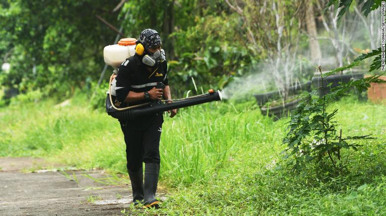 Một c&ocirc;ng nh&acirc;n phun thuốc diệt muỗi để chống lại bệnh sốt xuất huyết ở Singapore, ng&agrave;y 6/7/2021. Ảnh: CNN