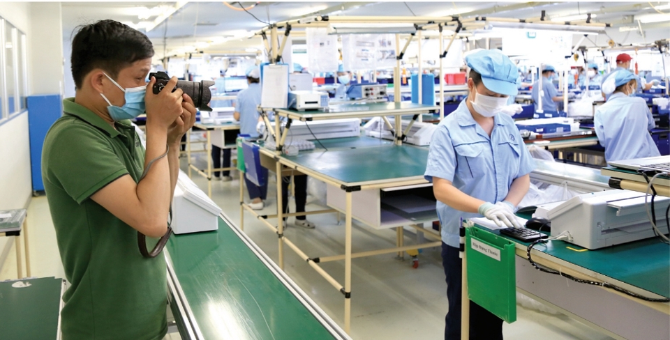 Phóng viên báo Kinh tế & Đô thị tác nghiệp phản ánh hoạt động phục hồi sản xuất tại Khu công nghiệp Nội Bài, Hà Nội. Ảnh: Công Hùng