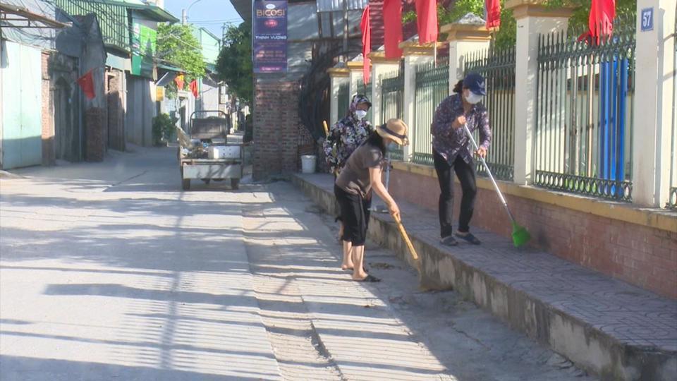 Người dân huyện Hoài Đức tham gia tổng vệ sinh đường giao thông. Ảnh: Nguyễn Trường