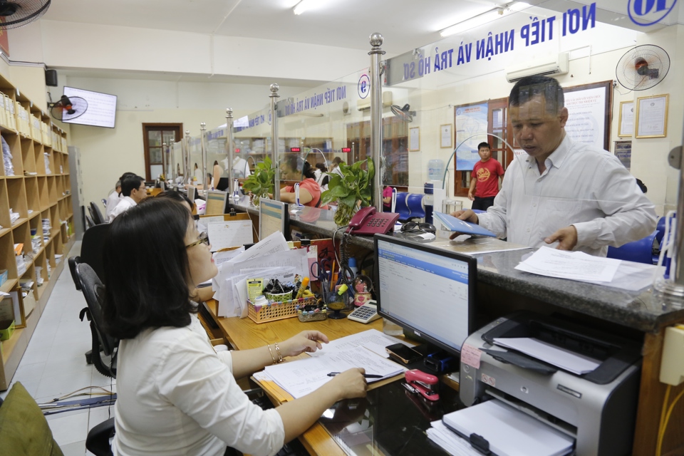 Hướng dẫn người dân làm thủ tục hành chính tại Bảo hiểm xã hội Hà Nội. Ảnh: Thanh Hải