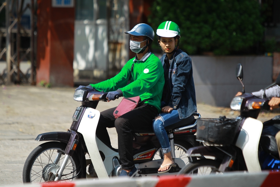 Lái xe GrabBike chở khách trên đường phố Hà Nội. Ảnh: Phạm Hùng