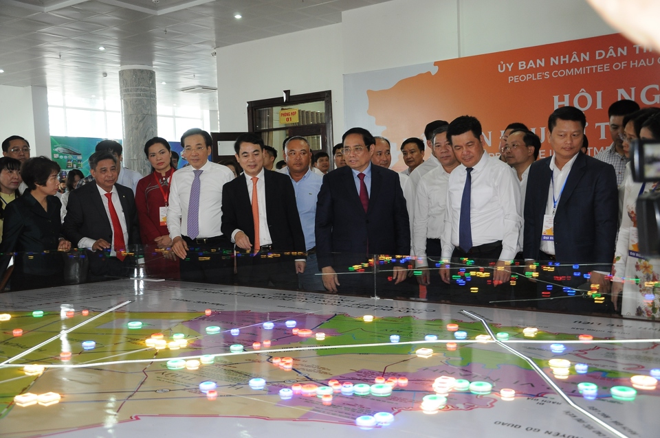 Thủ tướng Phạm Minh Ch&iacute;nh c&ugrave;ng đại biểu xem bản đồ c&aacute;c dự &aacute;n ở Hậu Giang. Ảnh: Giang Lam