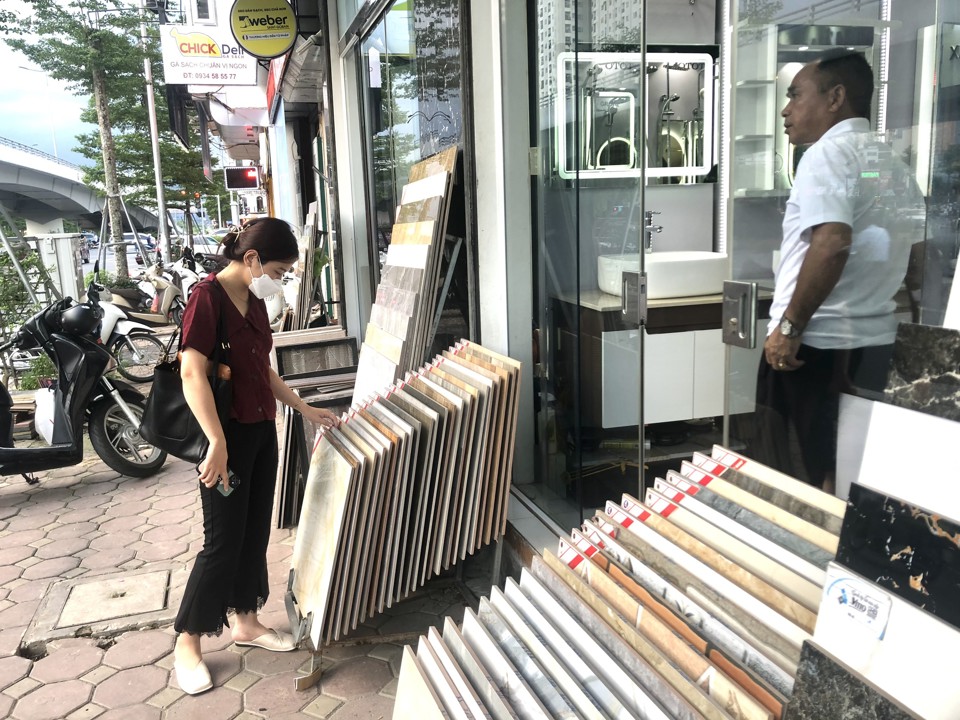 Khách hàng lựa chọn mẫu gạch tại cửa hàng VLXD trên đường Nguyễn Văn Huyên. Ảnh: Thành Luân