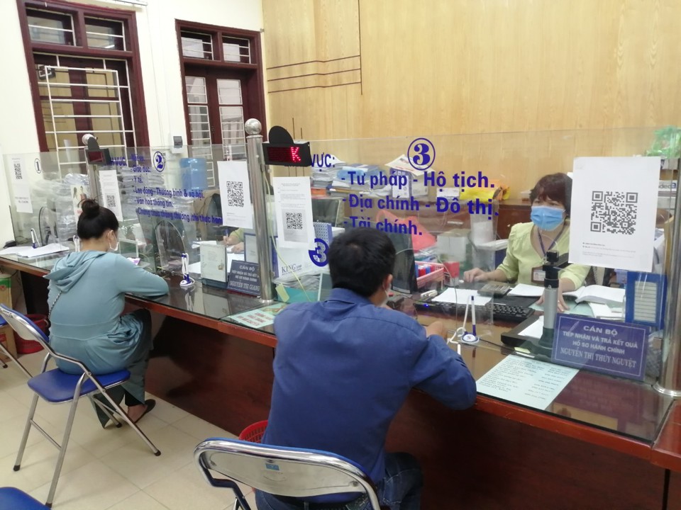 Công chức bộ phận một cửa UBND phường Vĩnh Tuy (quận Hai Bà Trưng) tiếp nhận giải quyết hồ sơ hành chính cho người dân. Ảnh: Thùy Linh