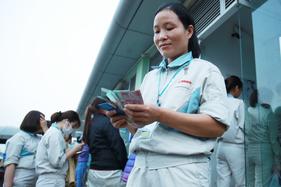 Người lao động làm việc tại Khu công nghiệp Thăng Long xếp hàng rút tiền lương tại cây ATM trong khuân viên Khu công nghiệp. Ảnh Công Hùng