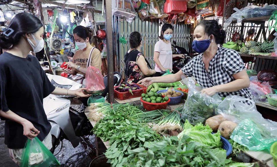 Người ti&ecirc;u d&ugrave;ng mua rau xanh tại chợ truyền thống
