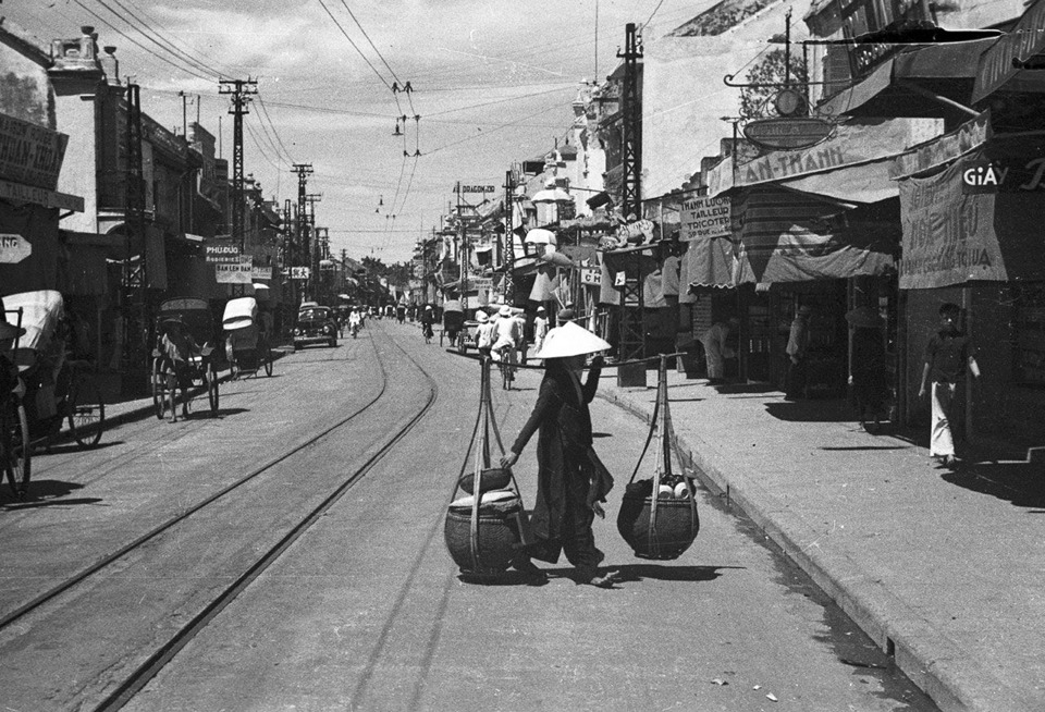 Người b&aacute;n h&agrave;ng rong tr&ecirc;n phố H&agrave;ng Đ&agrave;o năm 1940. Ảnh: Harrison Forman