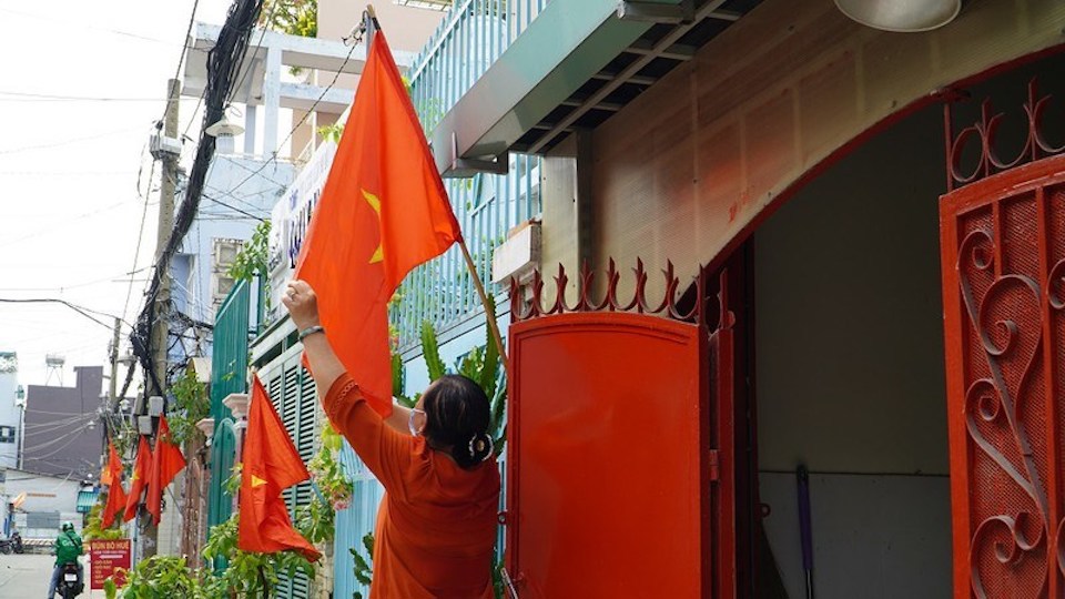 Một con hẻm tại TP Hồ Ch&iacute; Minh rợp b&oacute;ng cờ đỏ trước ng&agrave;y lễ 2/9/2021 Ảnh: PLO