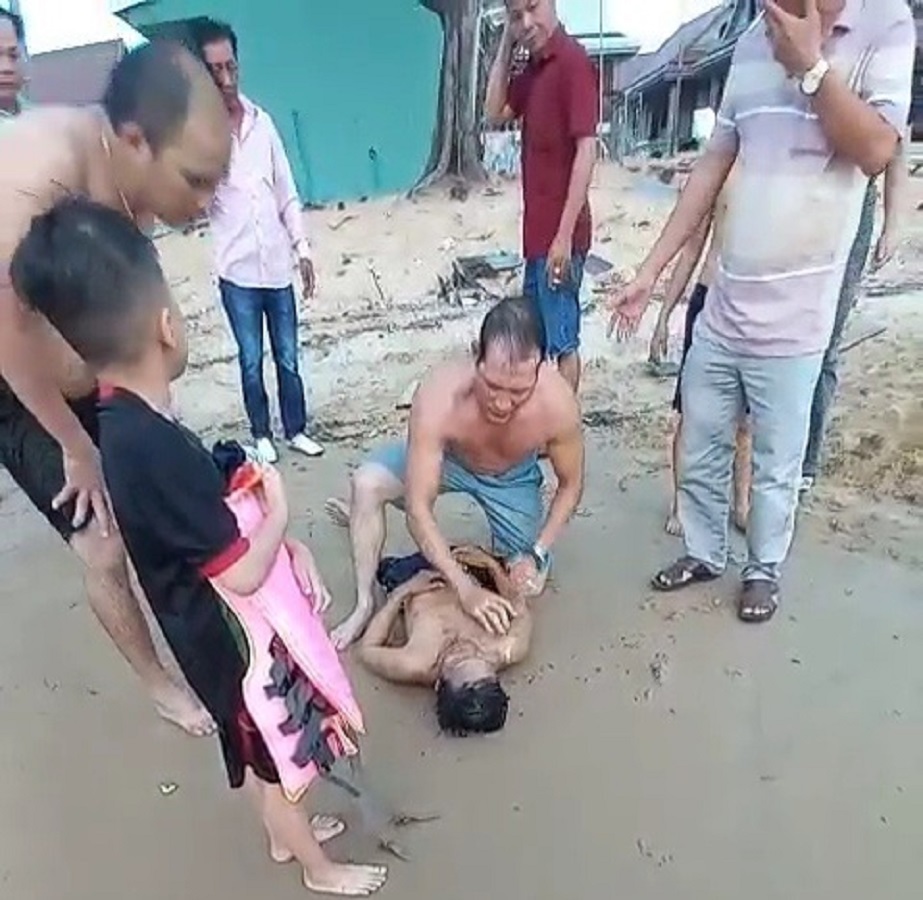 Người d&acirc;n tham gia sơ cứu cho &ocirc;ng Nguyễn Văn Th&aacute;i, người dũng cảm bơi ra biển cứu người (ảnh cắt từ clip)