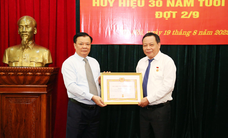 B&iacute; thư Th&agrave;nh ủy Đinh Tiến Dũng trao tặng Huy hiệu 30 năm tuổi Đảng cho đồng ch&iacute; Nguyễn Văn Phong.