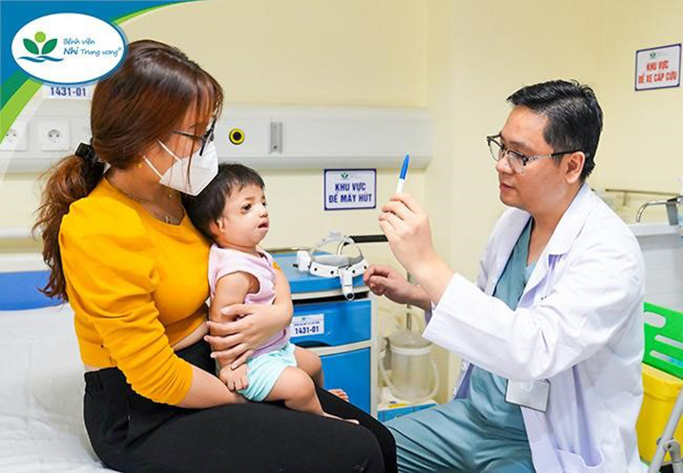 B&aacute;c sĩ Đặng Ho&agrave;ng Thơm đang thăm kh&aacute;m cho trẻ sau phẫu thuật v&ugrave;ng quanh ổ mắt.
