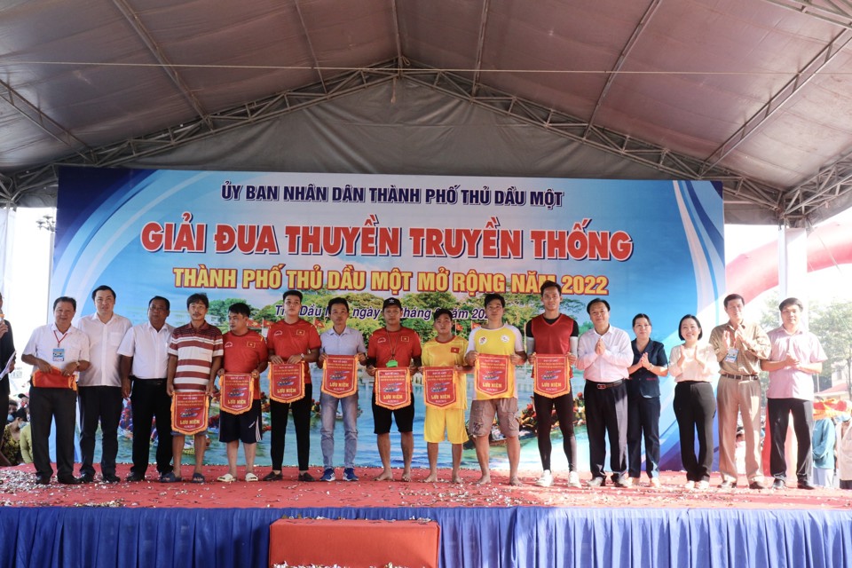 Ban tổ chức tặng cờ lưu niệm cho c&aacute;c đội tham gia giải đua thuyền truyền thống Thủ Dầu Một