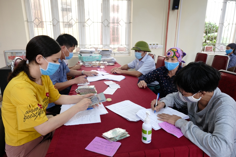 Trao tiền hỗ trợ cho người lao động bị ảnh hưởng bởi dịch Covid-19 trên địa bàn xã Đại Thịnh, huyện Mê Linh. Ảnh: Phạm Hùng