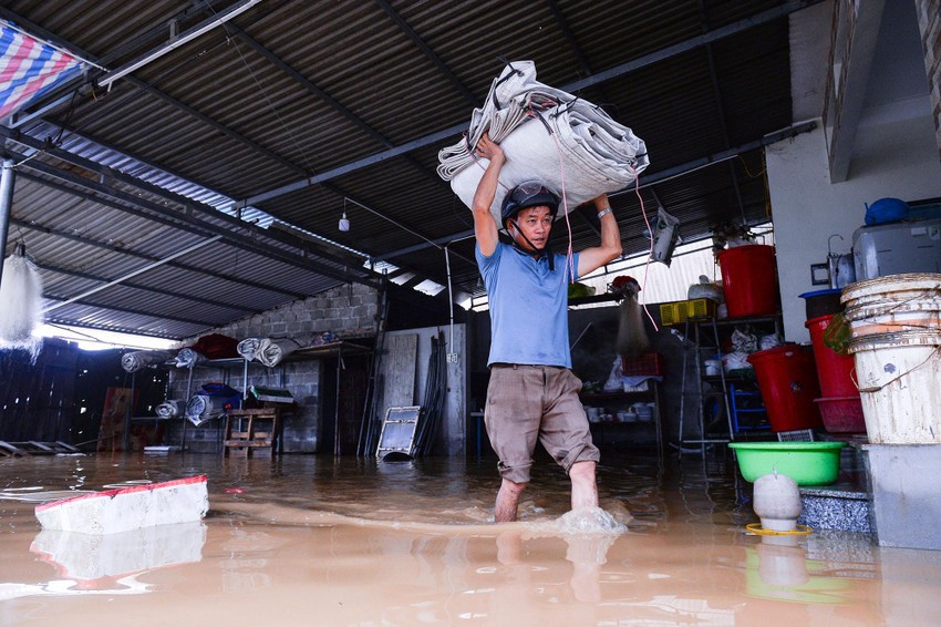 Người dân thị trấn Xuân Mai (huyện Chương Mỹ) di chuyển đồ đạc để tránh bị ngập nước. Ảnh: Phi Hùng