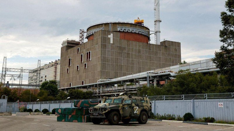 Xe quân sựNga bên ngoài nhà máy điện hạt nhân Zaporizhzhia, phía xa là mộttrong các lò phản ứng của nhà máy. Ảnh: Reuters