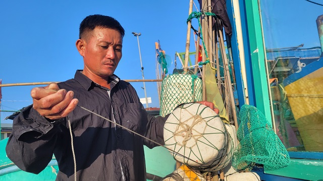 Ngư d&acirc;n Nguyễn Đức Hương buộc lại phao c&acirc;u mực, chuẩn bị cho chuyến vươn khơi đ&aacute;nh bắt thủy sản.
