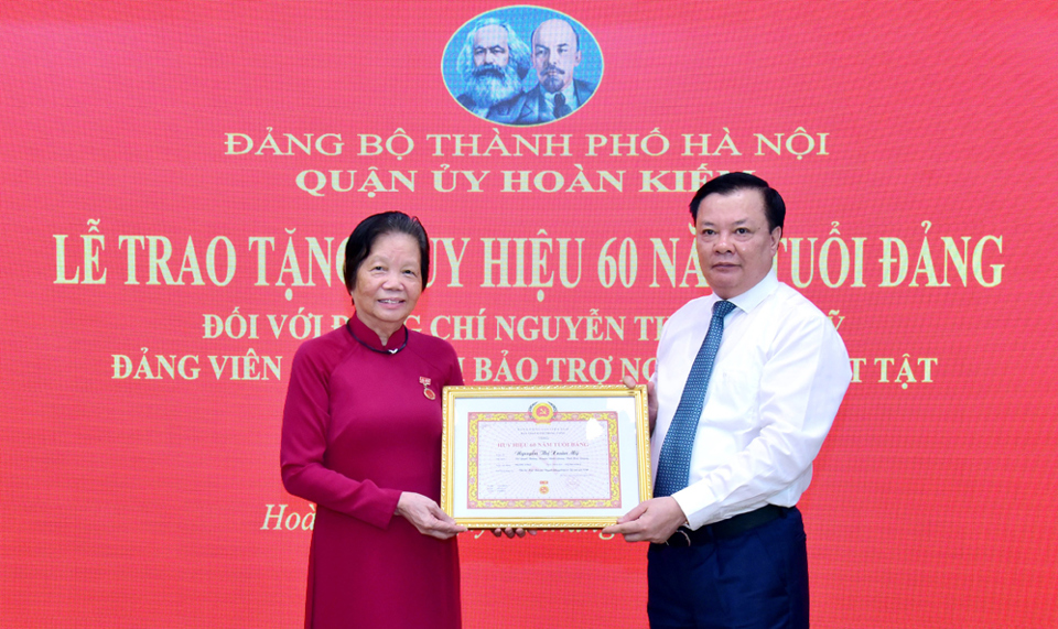 B&iacute; thư Th&agrave;nh ủy H&agrave; Nội Đinh Tiến Dũng trao Huy hiệu 60 năm tuổi Đảng cho đồng ch&iacute; Nguyễn Thị Xu&acirc;n Mỹ.