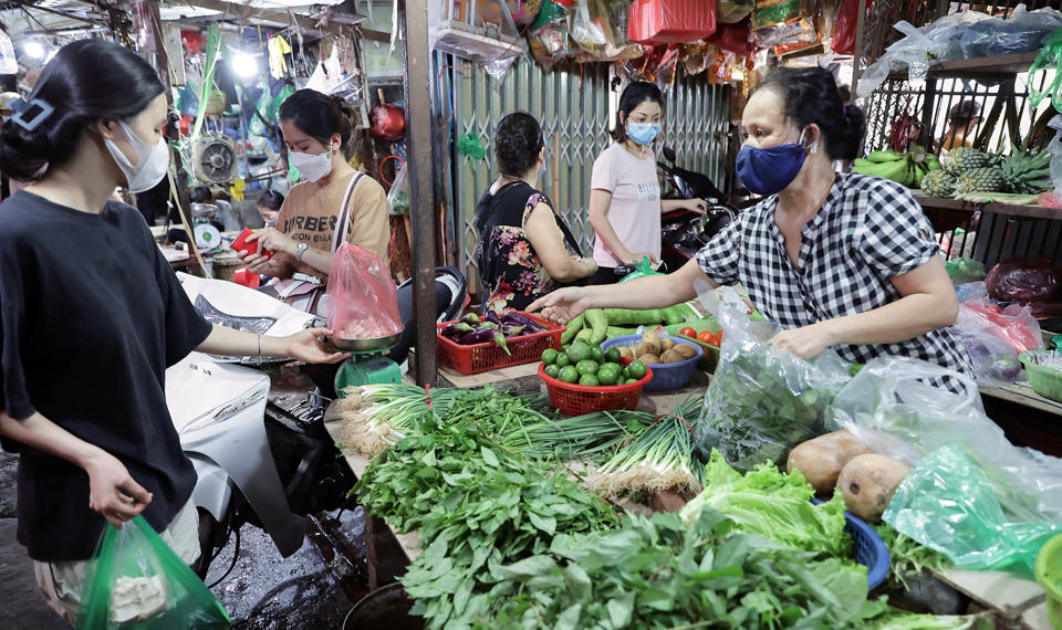 Người d&acirc;n mua rau xanh tại chợ truyền thống
