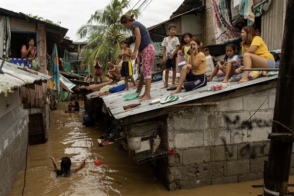 Người d&acirc;n phải tr&egrave;o l&ecirc;n m&aacute;i nh&agrave; do ngập lụt tại San Miguel, tỉnh Bulacan, Philippines, ng&agrave;y 26/9/2022. Ảnh:&nbsp; Reuters