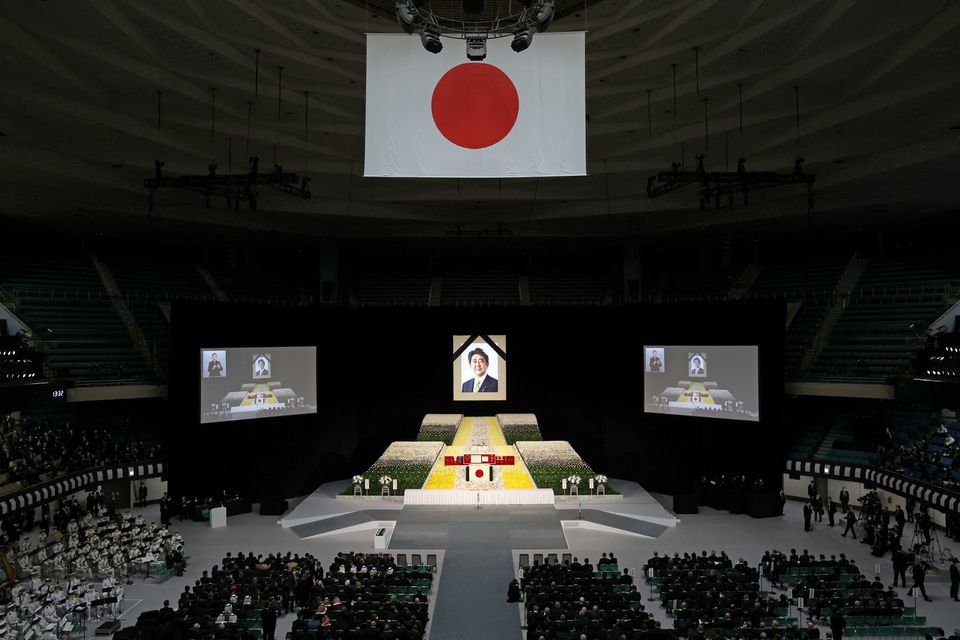 Bức ch&acirc;n dung của &ocirc;ng Abe được treo ph&iacute;a tr&ecirc;n s&acirc;n khấu trong hội trường nh&agrave; thi đấu Budokan ở Tokyo. Một số nguy&ecirc;n thủ quốc gia đương nhiệm v&agrave; cựu l&atilde;nh đạo đ&atilde; đến Nhật Bản dự sự kiện. Ảnh: Reuters