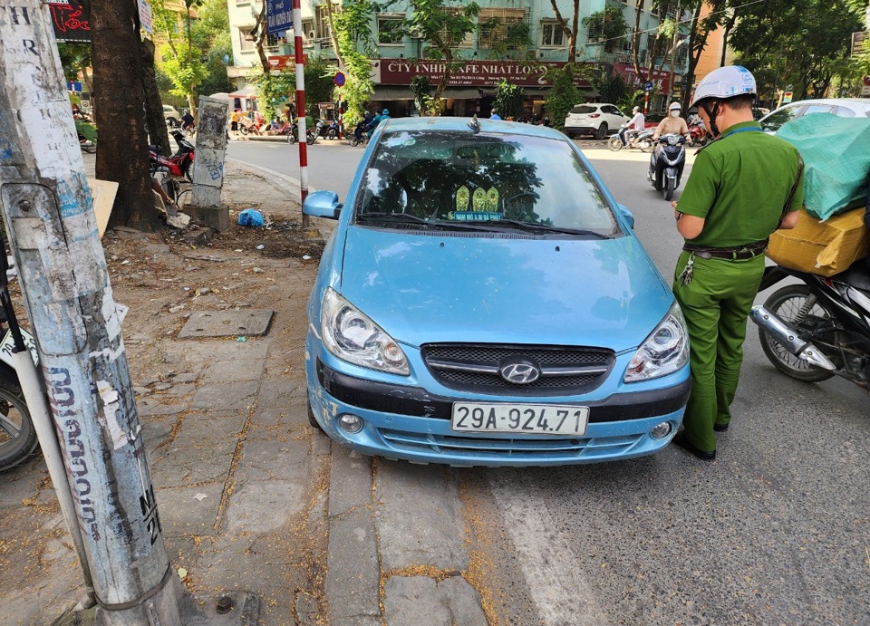 Lực lượng chức năng phường Định C&ocirc;ng tiến h&agrave;nh kiểm tra, xử l&yacute; một trường hợp xe &ocirc; t&ocirc; dừng đỗ sai quy định.