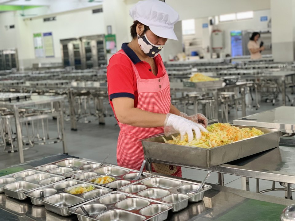 Nhân viên phục vụ bếp ăn bán trú tại trường THCS Yên Hòa, quận Cầu Giấy chuẩn bị các suất ăn cho học sinh (Ảnh: Nam Du)