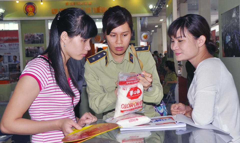 Quản lý thị trường Hà Nội hướng dẫn người tiêu dùng cách phân biệt hàng thật - giả tại hội chợ hàng Việt. Ảnh: Công Hùng