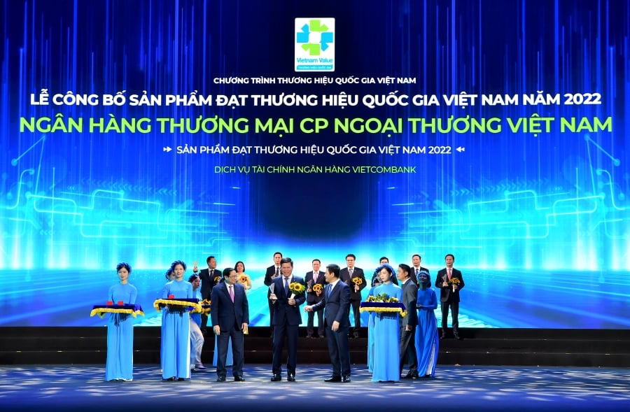 Thủ tướng Ch&iacute;nh phủ Phạm Minh Ch&iacute;nh (h&agrave;ng đầu thứ 3 từ tr&aacute;i sang) trao biểu trưng v&agrave; đ/c Nguyễn Hồng Di&ecirc;n - Bộ trưởng Bộ C&ocirc;ng thương, Chủ tịch Hội đồng Thương hiệu quốc gia Việt Nam (h&agrave;ng đầu thứ 2 từ phải sang) tặng hoa cho đ/c Phạm Mạnh Thắng - Ph&oacute; Tổng Gi&aacute;m đốc Vietcombank