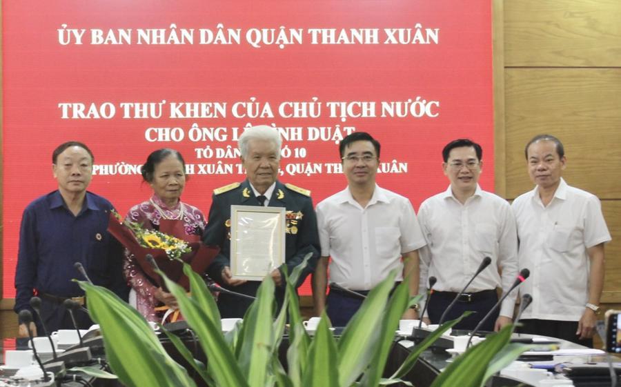 Đại diện UBND quận Thanh Xuân trao thư khen của Chủ tịch nước cho ông Lê Đình Duật (Tổ dân phố số 10, phường Thanh Xuân Trung, quận Thanh Xuân).